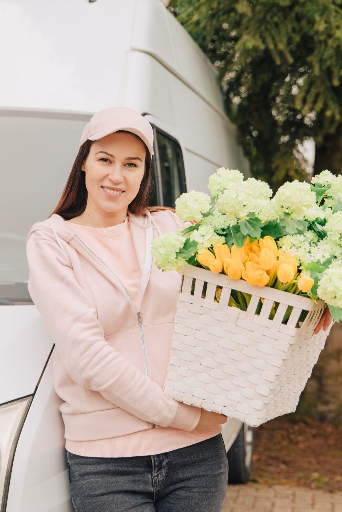 Femme portant un panier garni de fleurs fraîches